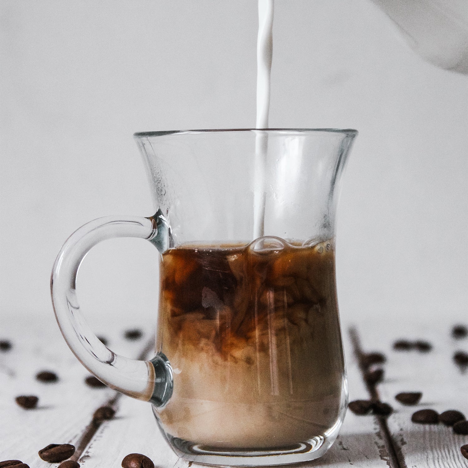 milk pouring into coffee